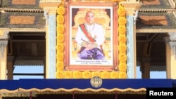 រូបឯកសារ៖ ព្រះឆាយាលក្ខណ៍​ព្រះបរមនាថ​ នរោត្តម​ សីហមុនី​ ព្រះ​មហាក្សត្រ​នៃ​ព្រះរាជាណាចក្រ​កម្ពុជា​ ដែល​ត្រូវ​បាន​ដាក់​តាំង​នៅ​មុខ​ព្រះ​បរម​រាជវាំង​ ក្នុង​​ឱកាស​ខួប​ទី​១០​នៃ​ព្រះ​រាជ​ពិធី​បុណ្យ​​គ្រង​រាជ​សម្បតិ្ត​ កាល​ពី​ល្ងាច​ថ្ងៃ​ទី​២៩ ខែ​តុលា​ ឆ្នាំ​២០១៤។ (រូបថត Reuters)
