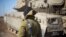 An Israeli soldier stand by a tank near the border with Syria in the Israeli-controlled Golan Heights, Nov. 28, 2016. A recent attack launched into northern Israel from Syria by militants apparently affiliated with IS have heightened fears in Israel.