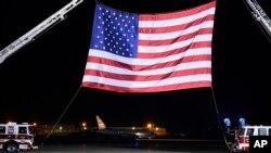 一架载有从朝鲜获释的三名美国公民的美国政府专机星期四凌晨在安德鲁斯联合基地降落，滑行到一面巨大美国国旗前 （2018年5月10日）