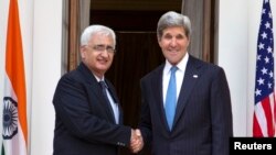 Menlu Amerika John Kerry (kanan), dalam kunjungan resmi pertamanya ke India sebagai Menteri Luar Negeri, berjabat tangan dengan Manlu India Salman Khurshid di Hyderabad, New Delhi (24/6).