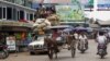 Vehicles make their way on a road near local bazaar in Mawlamyine, Mon State, Burma, March 11, 2011.