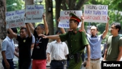 2016年7月17日在越南河内一名警察试图阻止反华抗议人士。