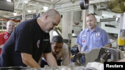 Presiden Obama (dua dari kanan) mengamati sebuah mesin yang sedang diproduksi saat mengunjungi Pabrik Pembuatan Mesin Daimler Detroit Diesel di Redford, Michigan, 10 December 2012. (REUTERS/Jason Reed)