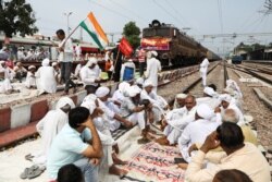Farmers block railway tracks as part of protests against farm laws during nationwide protests, in Sonipat, northern state of Haryana, India, Sept. 27, 2021.