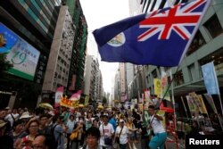 Çin idarəçiliyinə etiraz edən honq konqlular əllərində ərazinin Britaniya koloniyası dönəmindəki bayrağını yellədirlər.