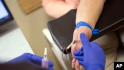 FILE - A patient has blood drawn at the Hospital of the University of Pennsylvania in Philadelphia, Oct. 6, 2016, after receiving a kidney transplant.