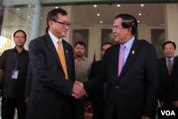 រូបឯកសារ៖ លោក​សម រង្ស៊ី ប្រធាន​គណបក្ស​សង្គ្រោះ​ជាតិ (ឆ្វេង) និង​លោក​នាយក​រដ្ឋ​មន្ត្រី​ហ៊ុន សែន (ស្តាំ) ចាប់​ដៃ​គ្នា​នៅ​រដ្ឋ​សភា​ជាតិ កាលពី​ខែ​មេសា ឆ្នាំ​២០១៥។