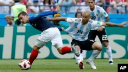 گریسمن، بازیکن تیم فرانسه یی که برای حفظ توپ با مدافع ارجنتاینی در کش و گیر است.