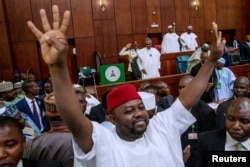 A man gestures as Nigeria's President Muhammadu Buhari presents the 2019 budget at the National Assembly in Abuja, Nigeria, Dec. 19, 2018.