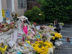 佐治亚议员碧·阮在一家发生枪击的亚特兰大按摩店前对海报拍照（美国之音记者文灏拍摄）