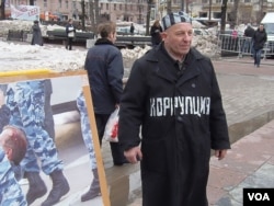 莫斯科支持政治犯集会的一名参加者把自己装扮成囚徒，他胸前的字是“腐败”。（美国之音白桦拍摄）