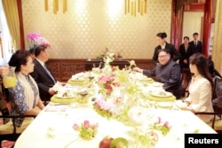 中国国家主席习近平和夫人彭丽媛，朝鲜国务委员会委员长金正恩和夫人李雪主在北京会面（2018年3月28日发布的照片，具体日期不详）。