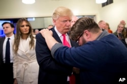 FILE - Pastor Joshua Nink, right, prays for Republican presidential candidate Donald Trump, after a Sunday service at First Christian Church, in Council Bluffs, Iowa, Jan. 31, 2016. At Friday's event, Trump appeared to make a special effort to use language that appeals to religious conservatives.