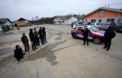 在塞尔维亚贝尔格莱德以北50公里的塞尔维亚北部城镇兹雷尼亚宁附近，在一家中国汽车轮胎工厂建筑工地打工的越南工人和塞尔维亚警察站在工房旁。（2021年11月18日）