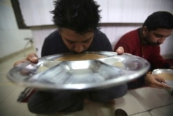 In this Thursday, Oct. 31, 2019, photo, recovering drug users eat a meal at a de-addiction center in Kapurthala, in the northern Indian state of Punjab. India has twice the global average of illicit opiate consumption. (AP Photo/Channi Anand)
