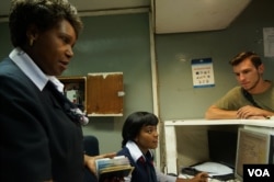 Lizzie Tchokhotho, checking passengers' passports, says the event was a morale booster for the women, at Chileka International Airport in Blantyre, Malawi, March 16, 2017. (L. Masina/VOA)