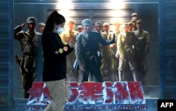 北京一家商场外的一幅“长津湖”电影海报。（2021年10月11日）