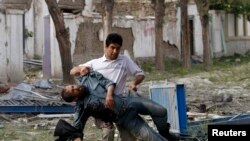 Wounded Afghan policeman is carried away from site of explosion, Kabul, May 24, 2013.
