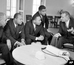 约翰逊总统(右)1964年1月在白宫与民权领袖交谈，左起第三人是马丁.路德.金