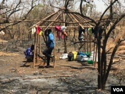 Two South Sudanese brothers build a hut at the Imvempi settlement in Arua district, Uganda, Jan. 30, 2018. (H. Athumani/VOA)