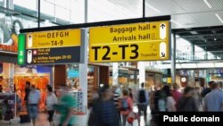 Passengers walk through a busy international airport.
