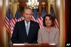 House Speaker Nancy Pelosi, right, and Senate Minority Leader Chuck Schumer pose for photographers after speaking on Capitol Hill in response President Donald Trump's prime-time address on border security, in Washington, Jan. 8, 2019.