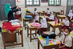 Siswa mengenakan masker di tengah pandemi COVID-19 saat menghadiri pembelajaran tatap muka di dalam kelas mereka pada hari pertama pembukaan kembali sekolah di sebuah sekolah dasar di Jakarta, 30 Agustus 2021.