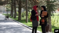 Female Afghan journalist, right, speaks with Adela Raz, deputy spokesperson to former Afghan President Hamid Karzai as they await a joint press conference by U.S. Secretary of State John Kerry and then-President Karzai, Presidential Palace, Kabul.