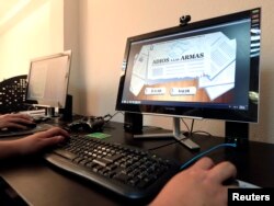 Colombian systems programmer Camilo Paez works on the video game "Adios a las Armas" (Farewell to Arms) in Bogota, Sept. 4, 2014.