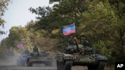 Arhiva - Proruski pobunjenici na tenkovima nose zastave samoproklamovane Donjecke Narodne Republike, snimljeni u blizini grada Novoazovsk, istočna Ukrajina, 21. oktobra 2015.