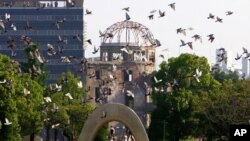 FILE - Burung merpati terbang melewati Kubah Bom Atom pada upacara peringatan 61 tahun pengeboman atom pertama di dunia di Taman Peringatan Perdamaian Hiroshima di Hiroshima, Jepang bagian barat, 6 Agustus 2006 (AP)