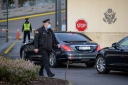 美俄为化解乌克兰危机在日内瓦举行会谈前，一名美国保安走过抵达美国驻日内瓦代表团驻地的俄罗斯官员乘坐的车队。（2022年1月10日）