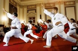 共和党众议员尼克·史密斯（左）和民主党众议员小杰西·杰克逊在参加李峻九大师在国会考核颁发跆拳道黑带的活动之前热身。（2001年7月23日）