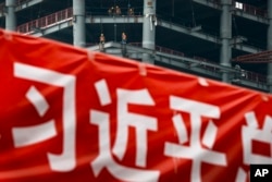 北京市中心的建筑工地与宣传习近平的横幅。（2017年4月16日）