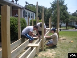 Yachad's teen volunteers build a wheelchair ramp at the New Carrollton, Maryland, home of Herson Portillo, 21, who has had cerebral palsy since birth. (Julie Taboh/VOA)