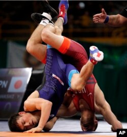 Japan's Yuki Takahashi, left, controls United States' Thomas Gilman, right, during their 57 kg match in the Freestyle Wrestling World Cup, April 7, 2018, in Iowa City, Iowa.