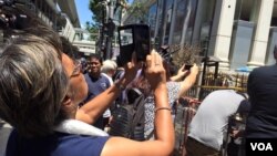 People take "selfies" in front of the Erawan Shrine, location of a bomb blast in central Bangkok, Thailand, Aug. 18, 2015. (Photo: Steve Herman / VOA)