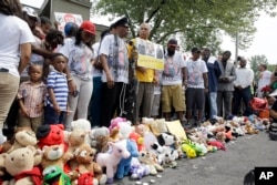 Keluarga, teman dan para warga mengheningkan cipta bagi Michael Brown, Minggu (8/8) di Ferguson, Missouri.