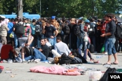 Hundreds of people waited outside the temporary camp all day, saying bad weather and lack of food and water is making more and more people sick. (Heather Murdock/VOA)