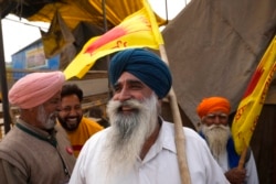Farmers celebrate news of the repeal of farm laws they were protesting against, in Singhu, on the outskirts of New Delhi, India, Nov. 19, 2021.