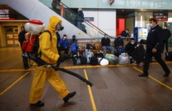 19일 러시아 모스크바의 기차역에서 방역 요원이 신종 코로나바이러스 감염 예방을 위한 소독을 하고 있다.