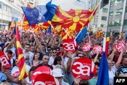 MACEDONIA -- People wave Macedonian and Europan flags as they attend a campaign rally for the "yes" ahead of a referendum on wether to change the country's name to "Republic of Northern Macedonia", in Skopje on September 16, 2018.