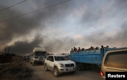 People stand at a back of a truck as they flee Ras al Ain town, Syria October 9, 2019. REUTERS/Rodi Said