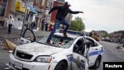 یکی از معترضان روی خودروی پلیس پریده است