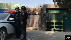 Çin polis qüvvələri "yenidən tərbiyə düşərgəsi" olduğu təxmin edilən mərkəzin önündə - Sincan muxtar bölgəsi, Korla şəhəri