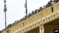 ადამიანები აკვირდებიან დუნაიზე სამაშველო სამუშაოებს