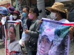 រូបឯកសារ៖ អ្នកតវ៉ានៅ​សាលា​ដំបូង​រាជធានី​ភ្នំពេញ កាល​ពី​ថ្ងៃ​ទី​១ ខែ​កក្កដា ឆ្នាំ​២០២១ កាន់​រូបថត​លោក តុន និមល អាយុ​៣៨ឆ្នាំ និង​អ្នកស្រី យ៉យ ស្រីមុំ អាយុ​៥០ឆ្នាំ នៅពេល​តុលាការ​ក្រុង​ភ្នំពេញជំនុំជម្រះ​ អ្នកចូលរួម​តវ៉ា​ក្នុង​ព្រឹត្តការណ៍​២៣ តុលា ឆ្នាំ២០២០ នៅ​មុខ​ស្ថានទូតចិន ប្រចាំ​កម្ពុជា។ (ហ៊ុល រស្មី/វីអូអេ)​