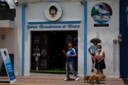 Turis berfoto di depan Gereja Maradona di San Andres Cholula, negara bagian Puebla, Meksiko, Minggu, 18 Juli 2021.