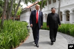 在新加坡圣陶沙的嘉佩乐酒店（Capella Hotel） 举行美国朝鲜峰会期间，美国总统川普与朝鲜领导人金正恩在午饭后散步（2018年6月12日）。