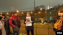 涅姆佐夫的一名支持者在他遇害的大桥上手举标语：英雄不死。（美国之音白桦拍摄）